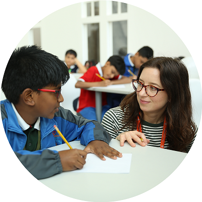 Emily Fellah helping a child with their drawing during a workshop